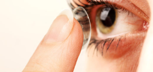 Woman inserting contact into eye
